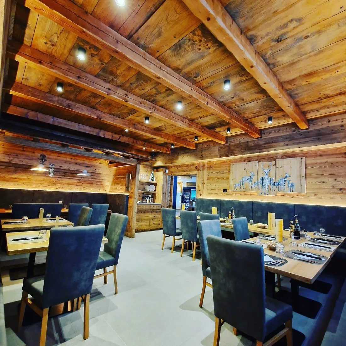 La sala del Cantuccio con travi a vista, pareti in legno e sedie imbottite